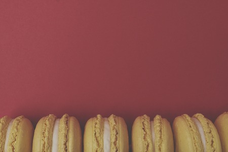 Flat lay yellow macaroons on red backgroundの写真素材