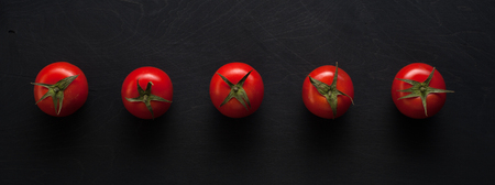 Row of cherry tomatoes on dark backgroundの写真素材