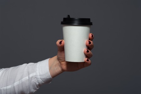 Closeup of office worker holding cup with coffeeの写真素材