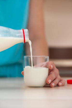 Woman pouring milk into glass