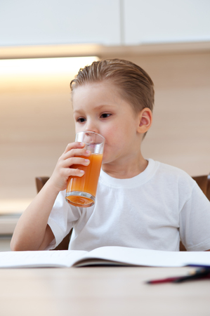 Little boy drinking fresh orange juiceの写真素材