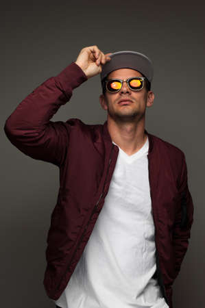 Young hipster in cap, jacket and spectacles eyeglasses.の写真素材