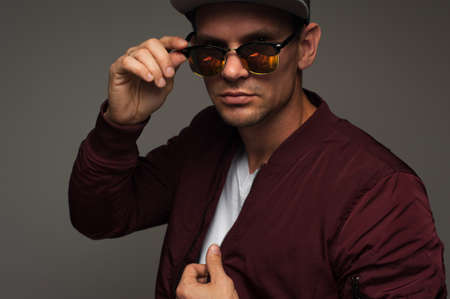 Young hipster in cap, jacket and spectacles eyeglasses.の写真素材