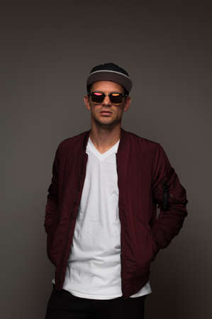Young hipster in cap, jacket and spectacles eyeglasses.の写真素材
