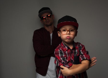Hipster father and son in caps and spectacles eyeglassesの写真素材