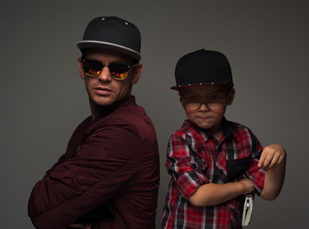 Hipster father and son in caps and spectacles eyeglassesの写真素材