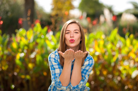Attractive woman sends an air kiss to the cameraの写真素材
