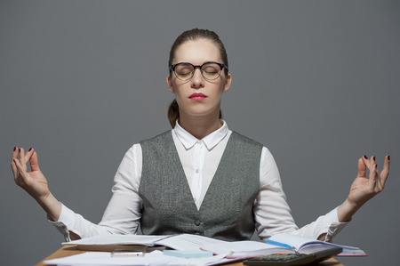 Businesswoman meditating sitting at the officeの写真素材