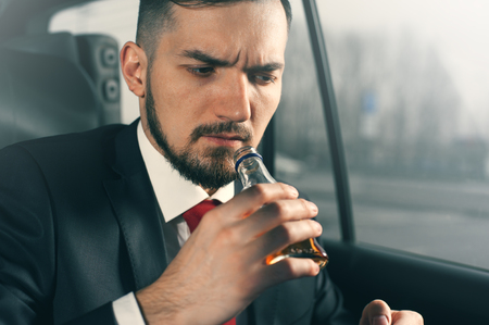 Young depressed businessman sitting in the car.の写真素材