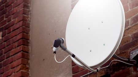 White satellite dish on the brick backgroundの写真素材