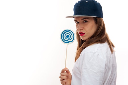 Woman in hip-hop cap holding lollipopの写真素材