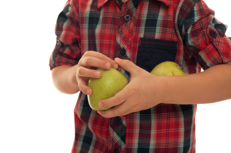 Child in red shirt holding two fresh green applesの写真素材