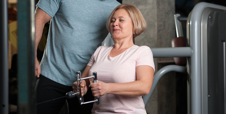 A male trainer helps his female clientの写真素材