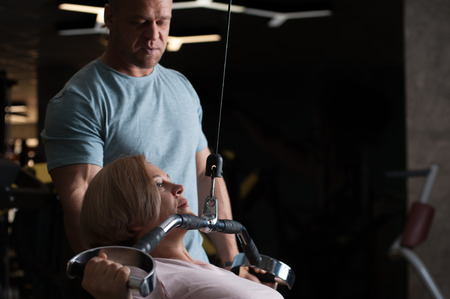 Strong male professional trainer helps his clientの写真素材