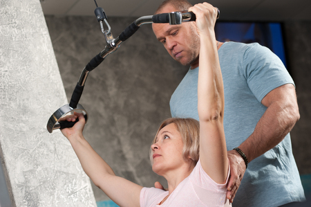 A male trainer shows how to do the exercisesの写真素材