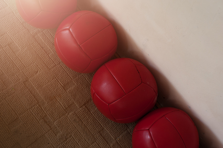 Row of red heavy balls in the corner of the roomの写真素材