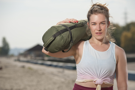 Portrait of attractive smiling woman training at the beachの写真素材