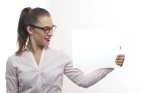 Young woman in eyeglasses point at white bannerの写真素材