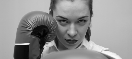 Strong and confident businesswoman wearing blouse and boxing glovesの写真素材