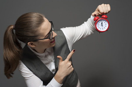 Atractive businesswoman holding clockの写真素材