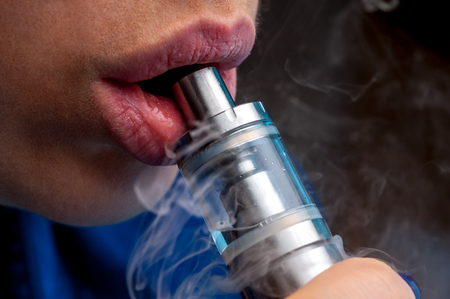 Close-up - young female vaping e-cigaretteの写真素材