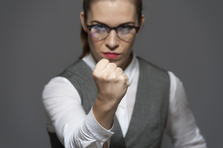 Angry unpleased attractive businesswoman looking at the camera showing fistの写真素材