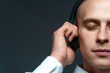 Young DJ guy listening to music in headphonesの写真素材