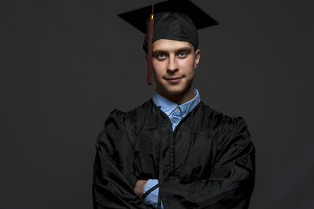 Caucasian male student wearing black mantle and blue shirtの写真素材