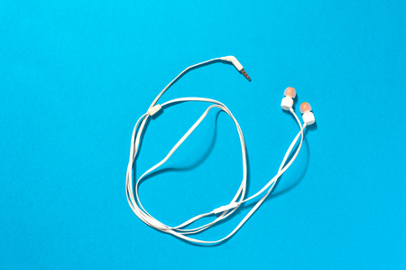 White earphones on blue background.の写真素材
