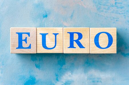 Wooden cubes with word EURO on blue table.の写真素材