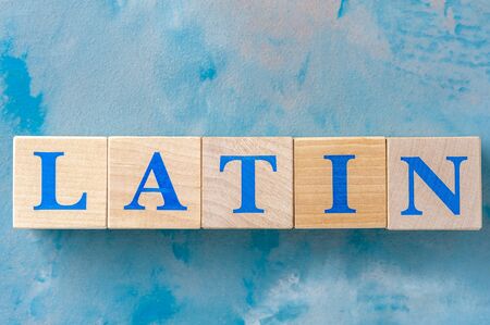 Wooden cubes with word LATIN on blue table.の写真素材