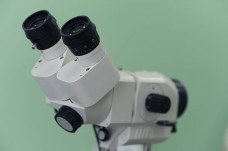 Close up magnifying glass microscope on a green background. Concept of research of analyzes and...