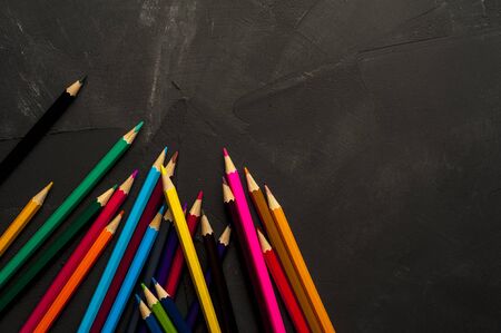 Colored sharpened pencils lie on the dark surfaceの写真素材