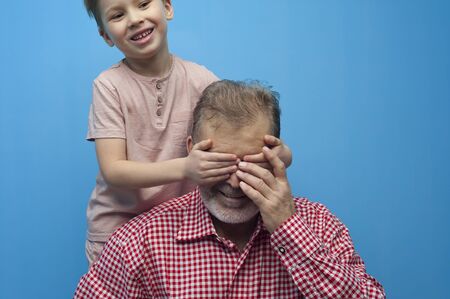 Positive little boy closes eyes to his grandfatherの写真素材