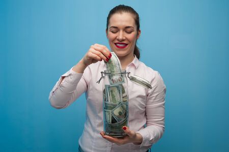 Young charming woman puts a banknoteの写真素材