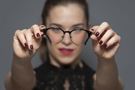 Young positive blurred woman holding glassesの写真素材