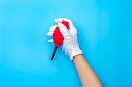 Top view female hand wearing white gloves cleaning up with air dust blower.の写真素材