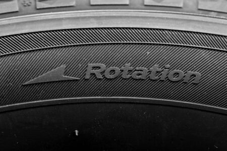 Close-up fragment of a car tire with the word rotation. Automotive industry concept. The concept of seasonal tire updates. Motorcycle repair conceptの写真素材