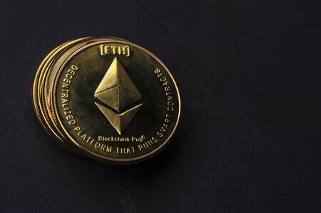 Close-up of a gold Bitcoin coin lies on a black background. The concept of modern currencies and...