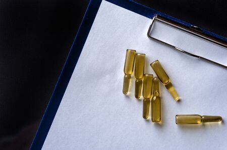 Close-up glass ampoules with medicine on empty sheetの写真素材
