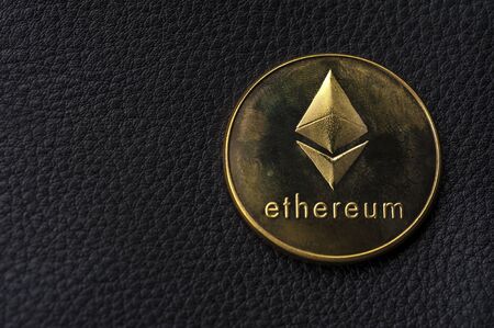 Golden coin lies on a black background. The concept of modern currencies and mining. Place for...