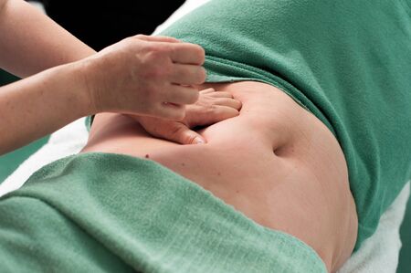 Woman massage the stomach of unknown womanの写真素材