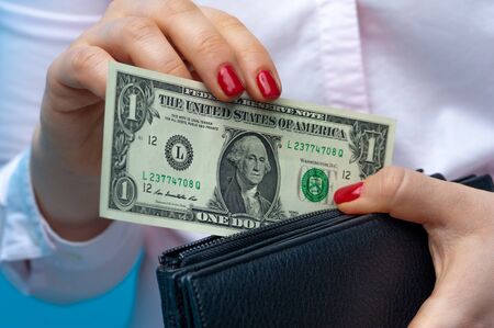 Close-up of a womans hands putting banknotes of one dollarの写真素材