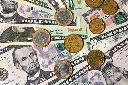 Dollar bills and coins lie next to each otherの写真素材