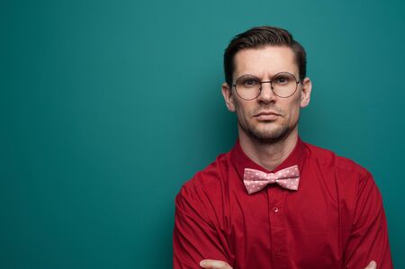 Portrait of a serious young man in a red shirtの写真素材