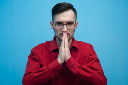Young man in glasses and a burgundy shirtの写真素材