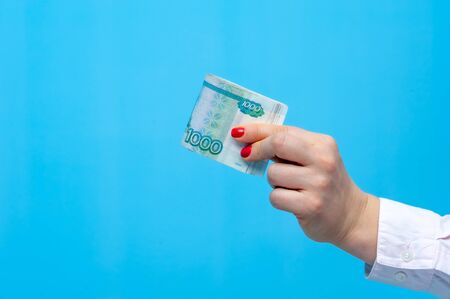 Hands of a young unidentified woman with pack of rubles