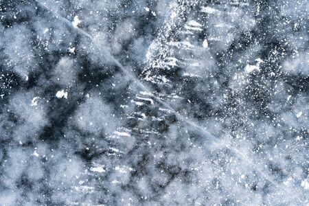Top view of a snowy white surface of a frozen ice river with clear blue water in winter. The concept of crusts of natural phenomena and objects. Advertising spaceの写真素材