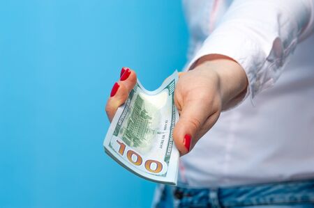 Hands of a young unidentified woman with pack of dollarsの写真素材