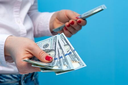 Hands of a young unidentified woman with pack of dollarsの写真素材